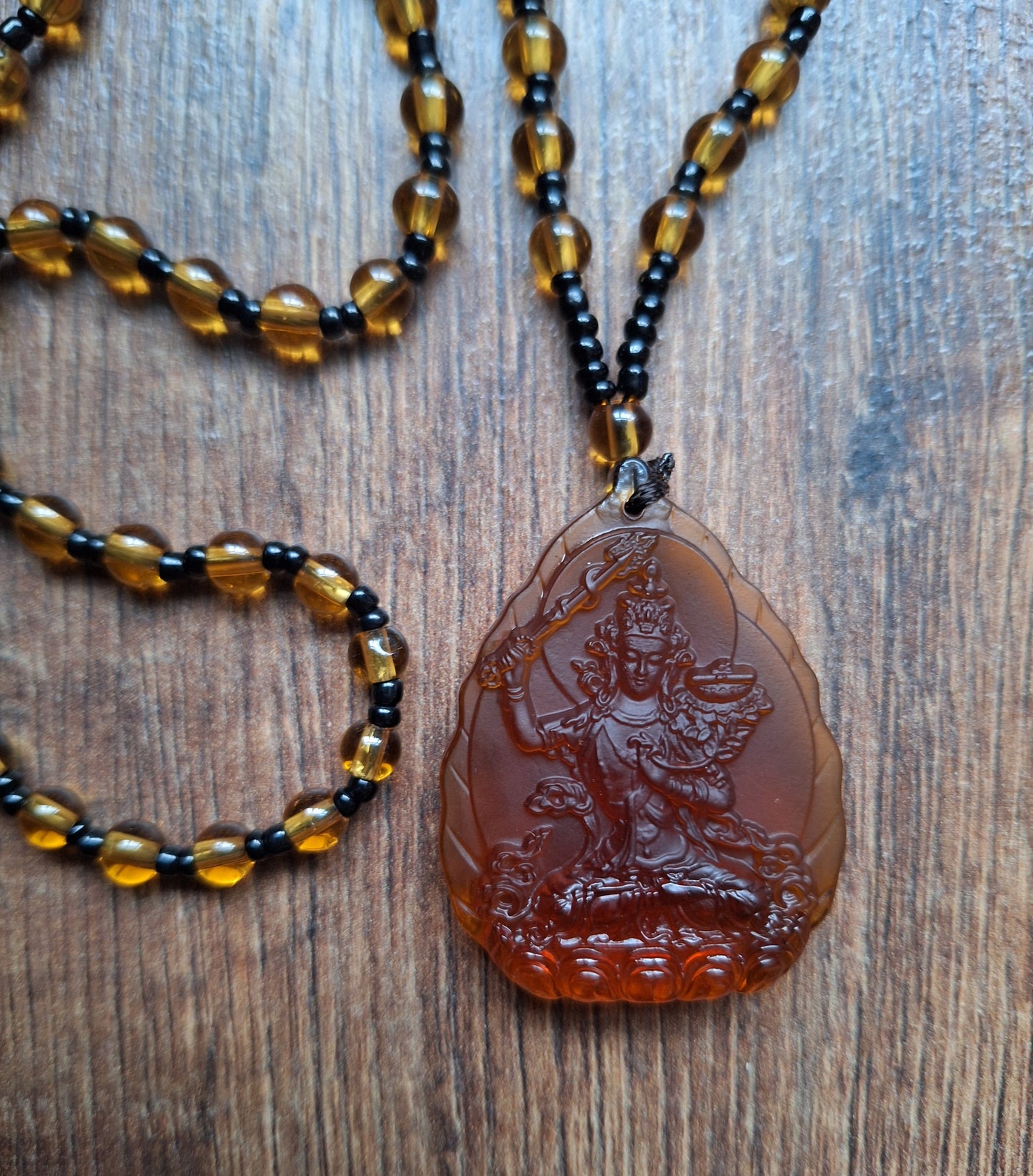 Orange glass necklace with Manjushri pendant