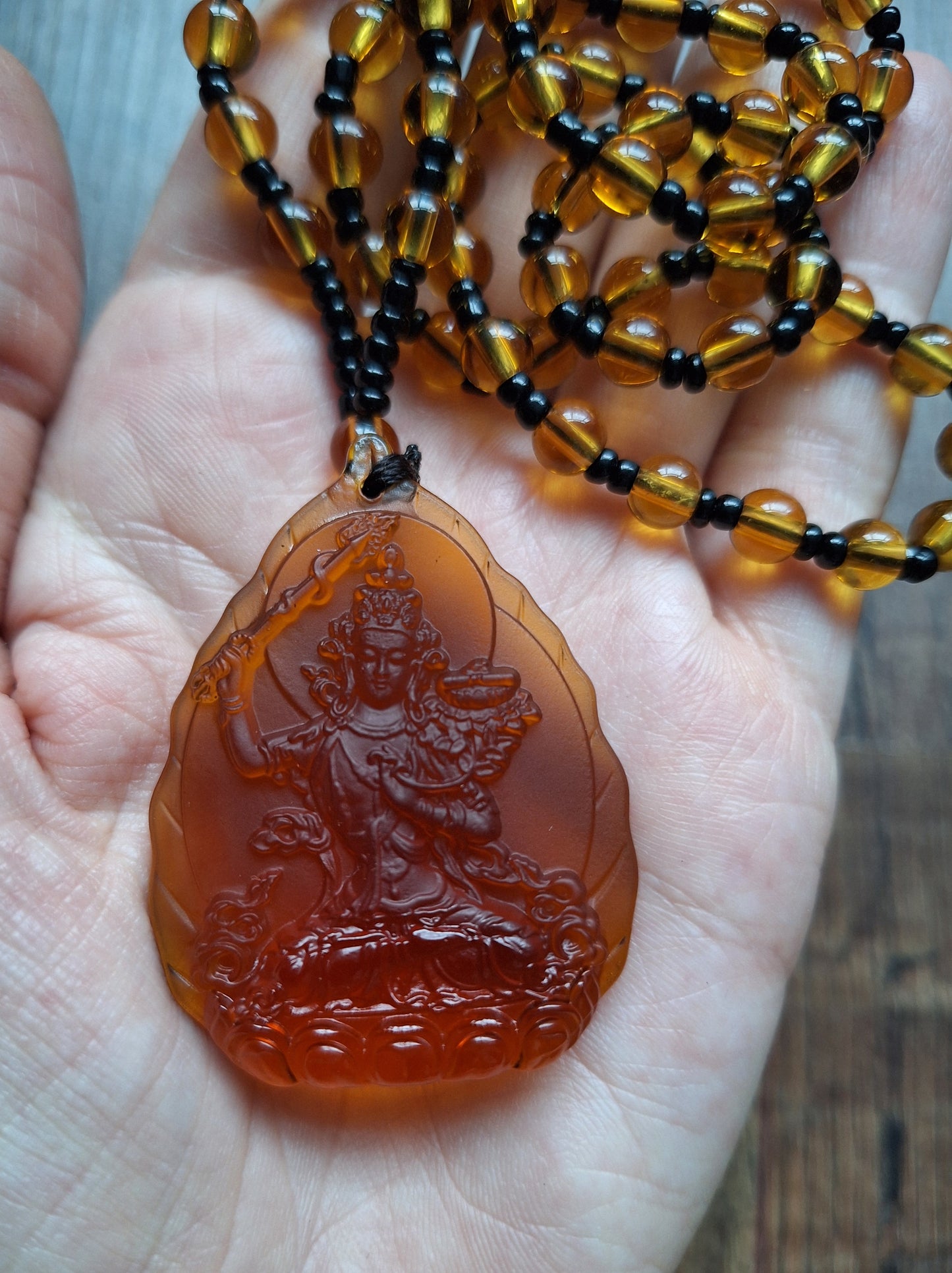 Orange glass necklace with Manjushri pendant