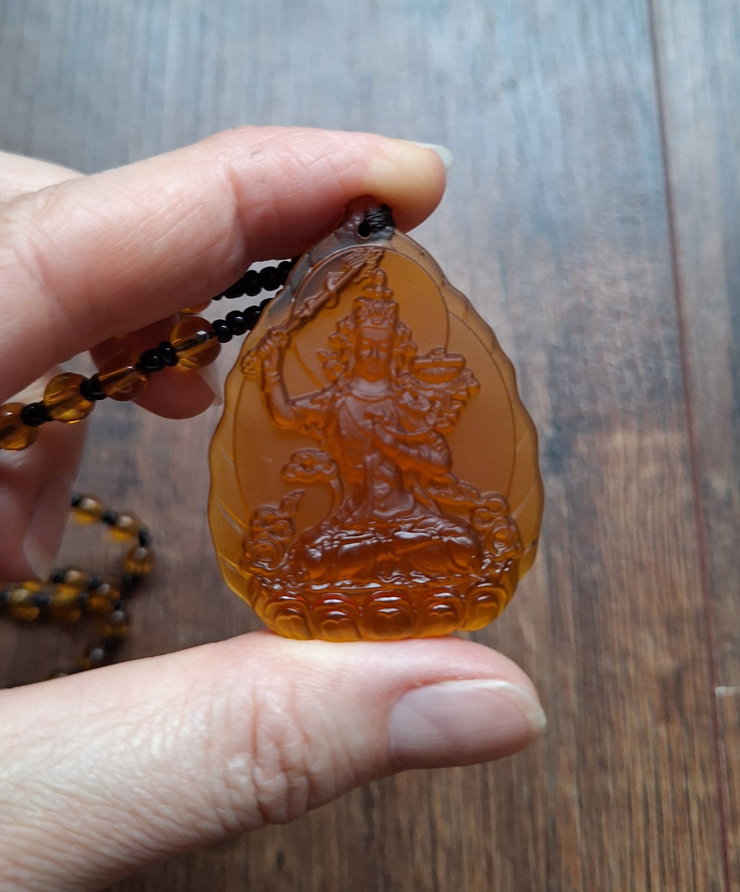 Orange glass necklace with Manjushri pendant