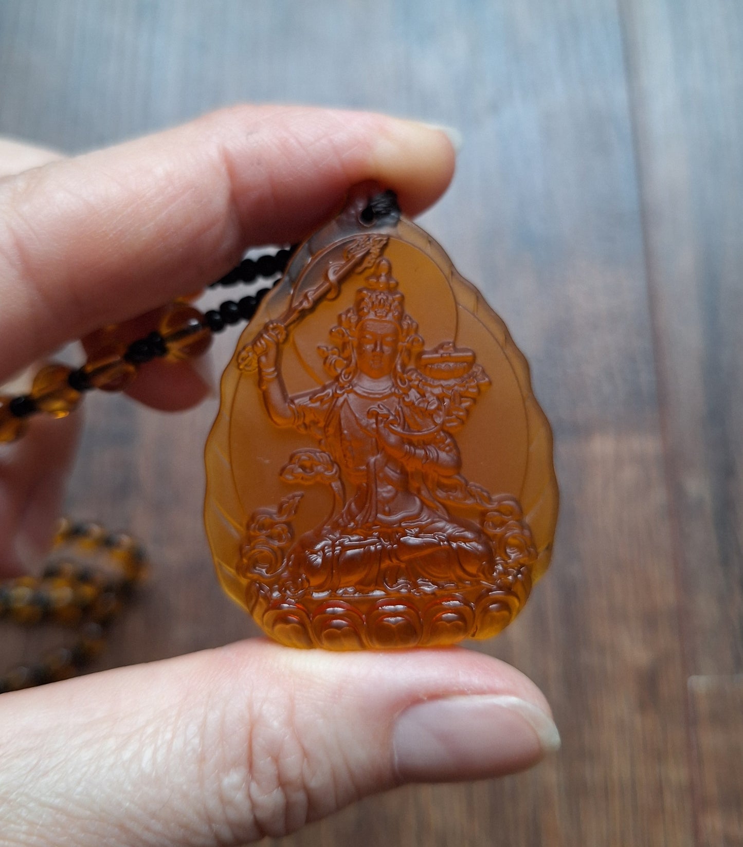 Orange glass necklace with Manjushri pendant