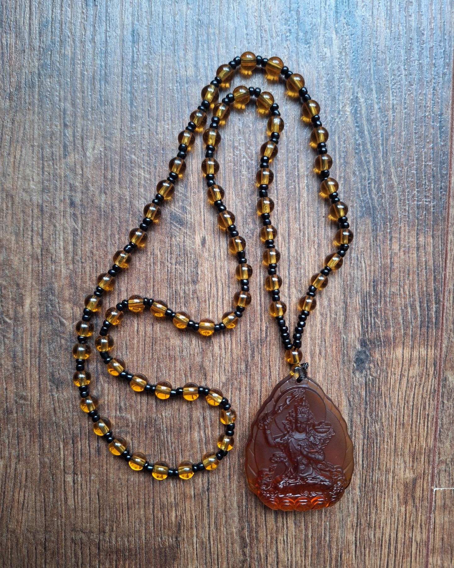 Orange glass necklace with Manjushri pendant
