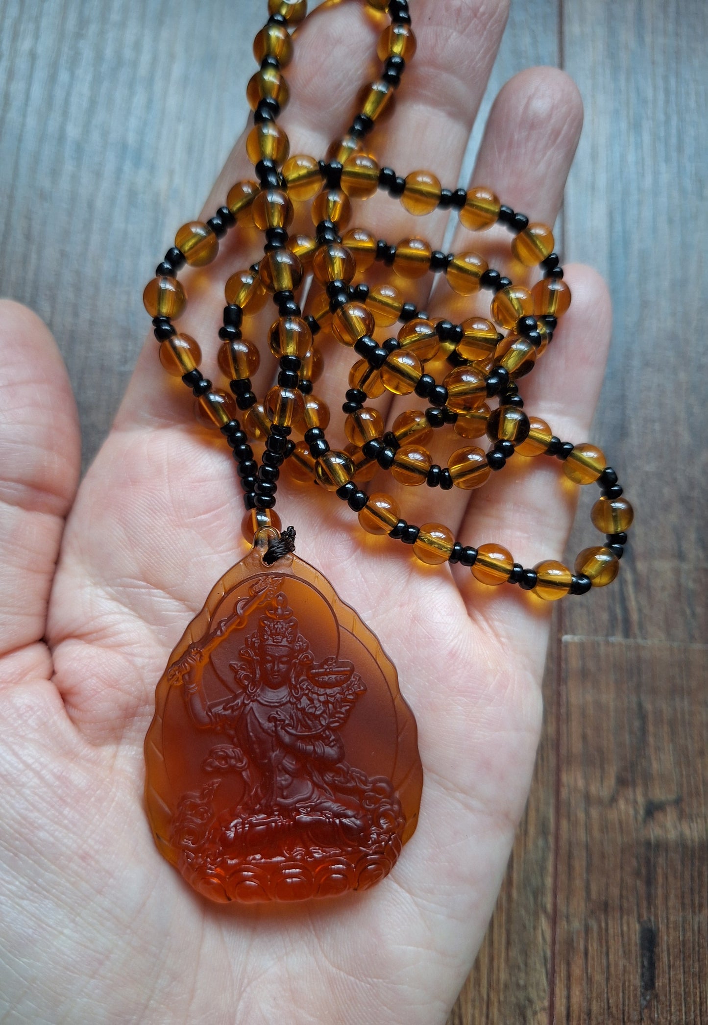 Orange glass necklace with Manjushri pendant