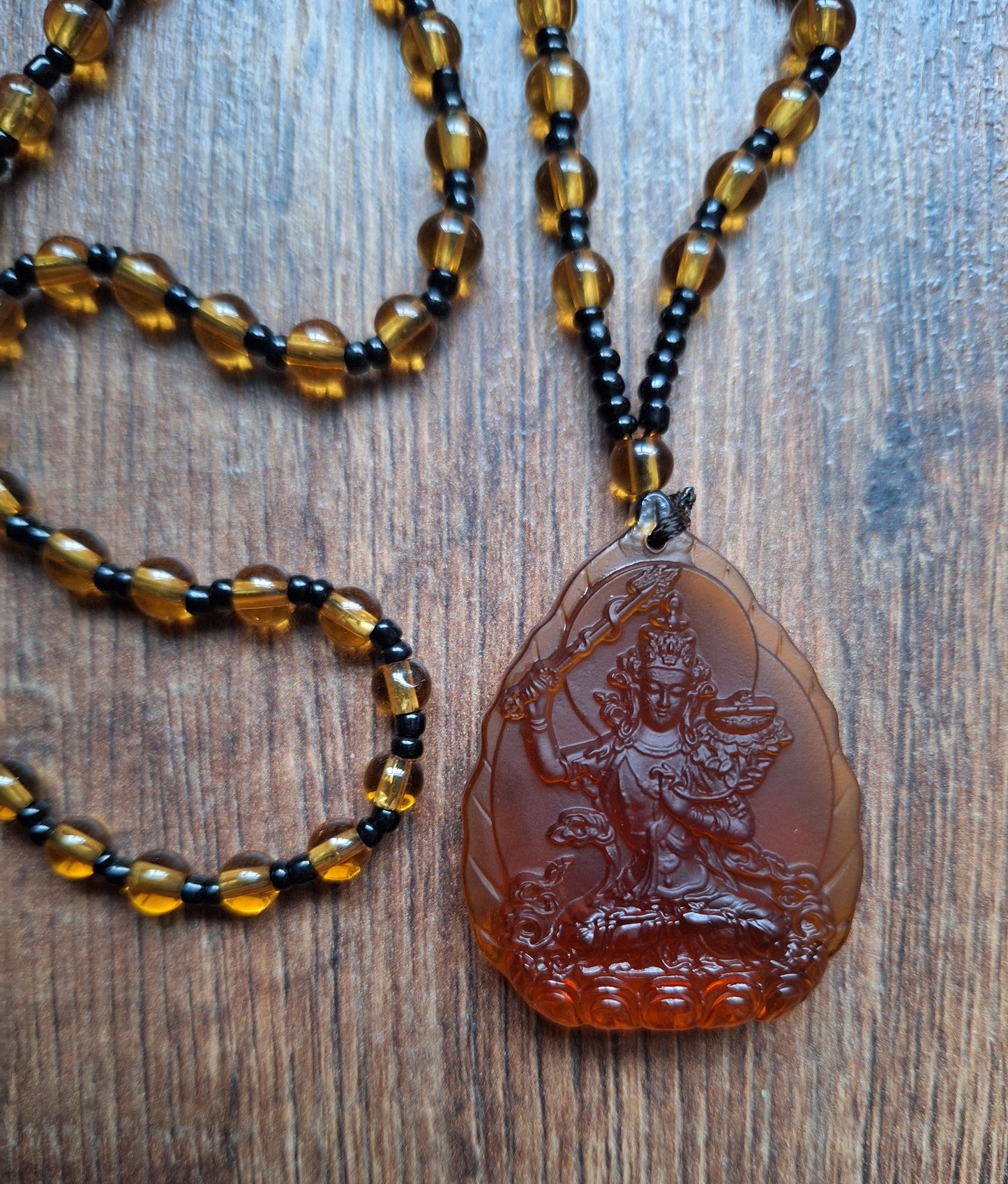 Orange glass necklace with Manjushri pendant